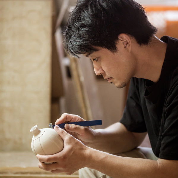愛知県瀬戸市の瀬戸焼作家・樽田 裕史さん。白磁の壺に工具で線状の透かし彫りを入れる「蛍手」の制作中。テーブルウェア・フェスティバル最優秀賞受賞