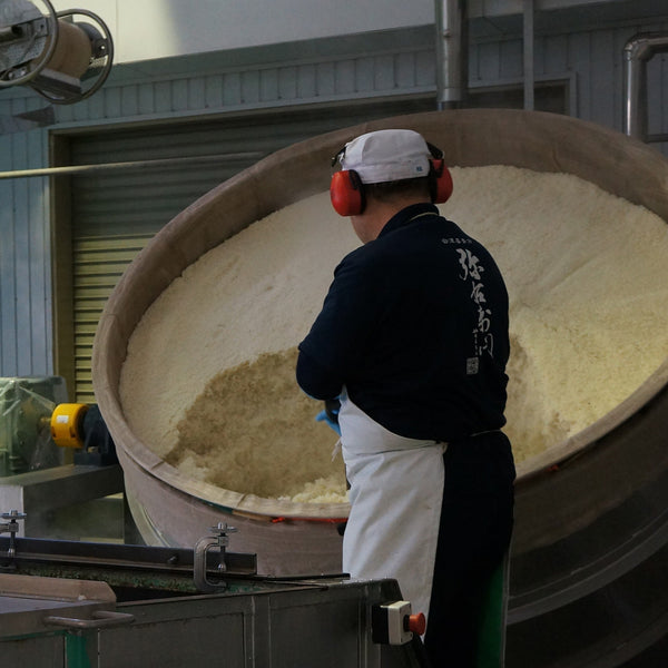 福島・喜多方で230年続く「大和川酒造店」の蔵人が、大型木桶で蒸した酒米を確認する。自社栽培の酒米と飯豊山の雪解け水で醸す純米大吟醸